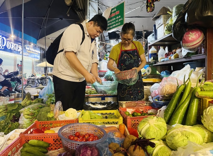 Người dân mua rau ở chợ Cống Vị, Ba Đình tối 12/11. Ảnh: Phan Dương