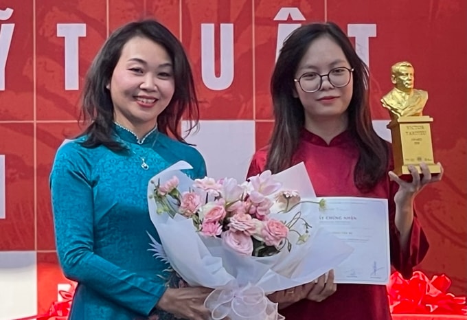 Đặng Thị Phong Lan - hiệu trưởng trường Đại học Mỹ thuật Việt Nam (trái) trao bằng khen và cúp cho Nguyễn Dương Trà Mi. Ảnh: Phương Linh