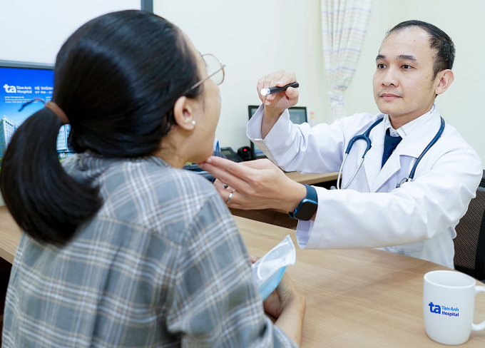 Bác sĩ Minh Thuận đang kiểm tra họng cho người bệnh. Ảnh: Bệnh viện Đa khoa Tâm Anh