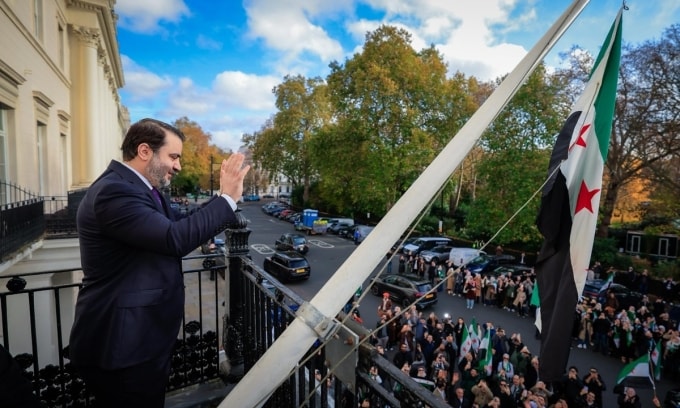 Ngoại trưởng Syria Asaad al-Shaibani vẫy tay với đám đông từ ban công đại sứ quán nước này ở trung tâm thủ đô London, Anh, ngày 13/11. Ảnh: X/Asaad al-Shaibani