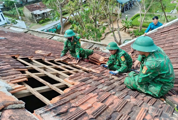 Bộ đội giúp dân lợp nhà sau bão lũ ở Hà Tĩnh. Ảnh: Đức Hùng