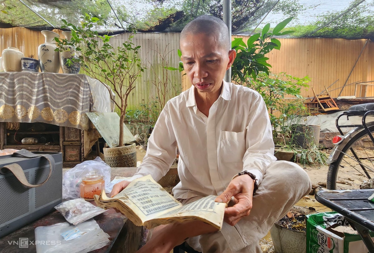 Tiến sĩ Đoàn Trung Hữu tiếc nuối những cuốn sách cổ bị lũ nhấn chìm. Ảnh: Võ Thạnh