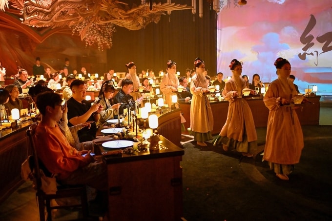 Nhân viên phục vụ ăn mặc, trang điểm theo chủ đề cổ đại bê thức ăn tới bàn cho thực khách trong nhà hàng ở Bắc Kinh ngày 2/11. Ảnh: AFP