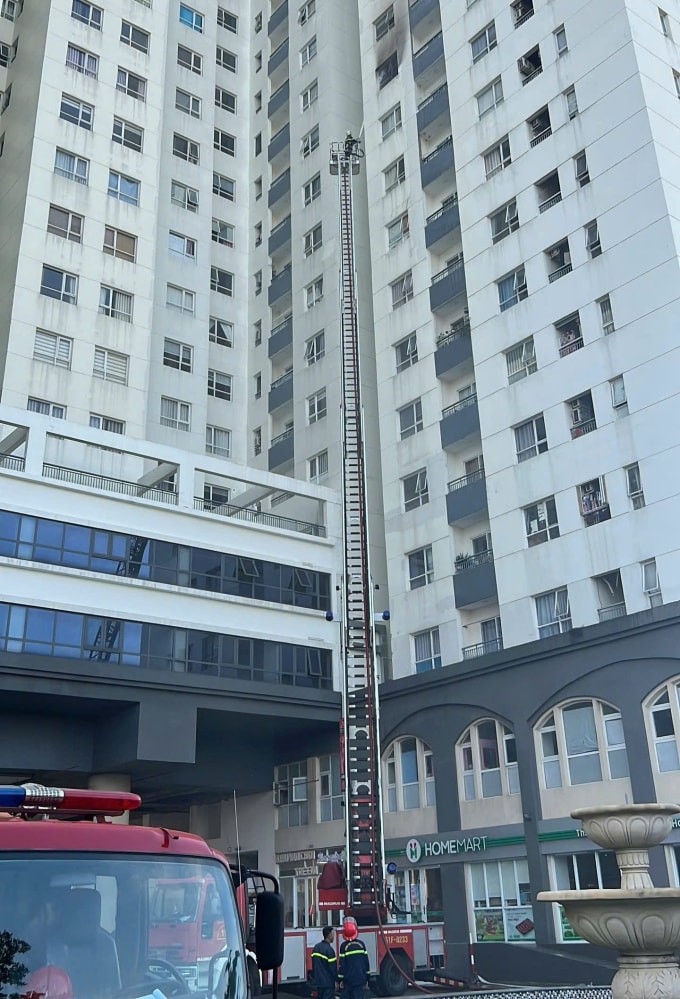 Xe thang vươn cao hơn 30 m để dập lửa căn hộ cháy ở tầng 12. Ảnh: Minh Hoàng