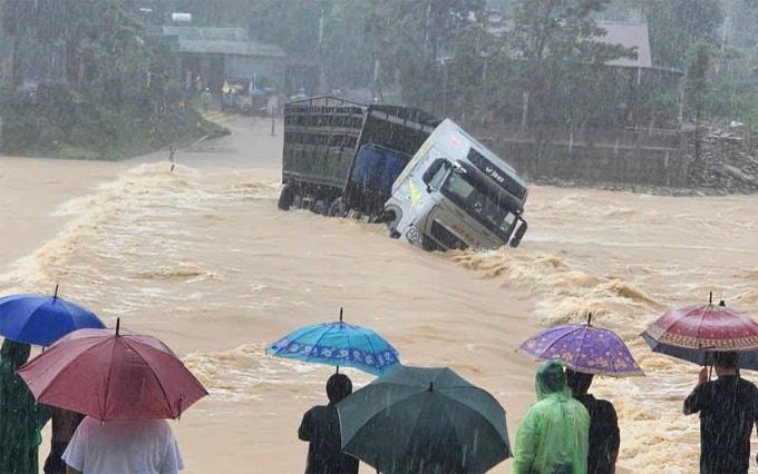 Xe đầu kéo vượt qua cầu tràn nước lũ chảy xiết bị cuốn trôi. Ảnh: Văn Đỗ