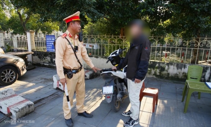 Một tài xế dùng khẩu trang che biển số, bị CSGT xử phạt. Ảnh: Việt An