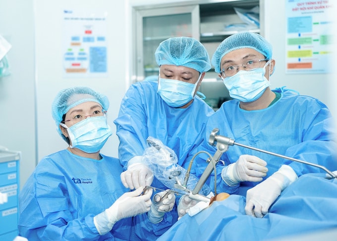 Bác sĩ Hằng (trái) đang phẫu thuật cho người bệnh khàn tiếng vì polyp dây thanh. Ảnh: Bệnh viện Đa khoa Tâm Anh