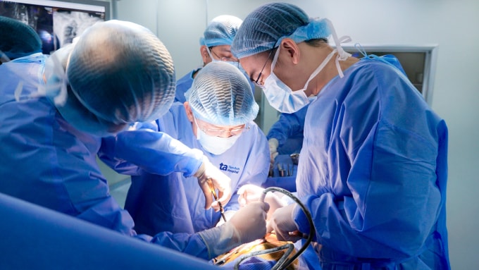 Bác sĩ Hiển (giữa) phẫu thuật giải ép, loại bỏ lao cột sống cho ông Niên. Ảnh: Bệnh viện Đa khoa Tâm Anh