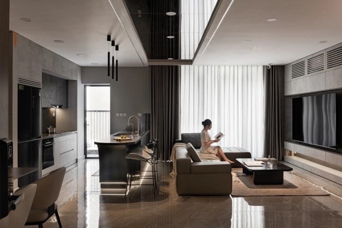 Tông xám đen trung tính xuyên suốt toàn bộ không gian, kết hợp với hệ đèn trang trí và đèn chiếu điểm ánh sáng ấm, vừa tăng chiều sâu thị giác, vừa giúp không gian trở nên sinh động, hạn chế cảm giác đơn điệu thường thấy ở màu tối. Ảnh: Humi Studio