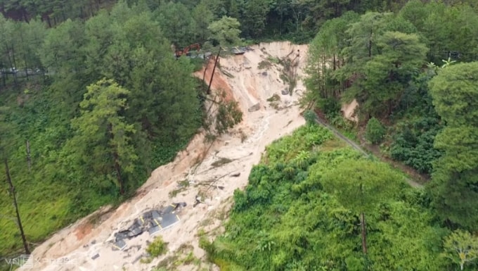 [Đoạn đèo Mimosa trên quốc lộ 20 qua phường Xuân Hương - Đà Lạt sau sạt lở, sáng 20/11. Từ trên cao, kết cấu đường nhựa biến mất, để lại một vết sạt lớn ước tính rộng 50 m, sâu gần 30 m. Ảnh: Khánh Hương - Trường Hà
