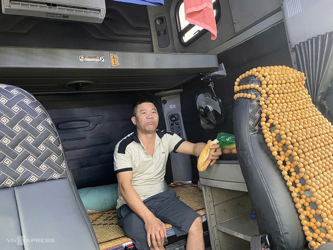 Tài xế Đỗ Xuân Định ăn bánh mì, chờ đợi nước rút, sáng 20/11. Ảnh: Trần Hoá