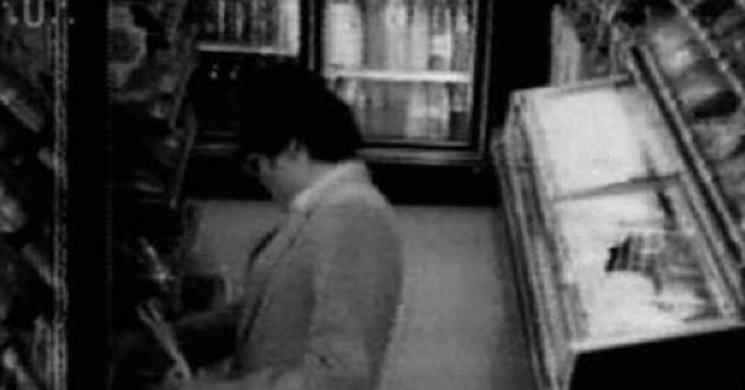 Kẻ tình nghi đặt thanh socola lên kệ hàng. (Nguồn: Allday)