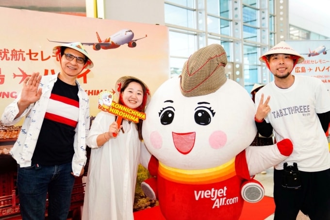Du khách trên chuyến bay đến Hiroshima chụp ảnh cùng linh vật của Vietjet. Ảnh: Tài Nguyễn