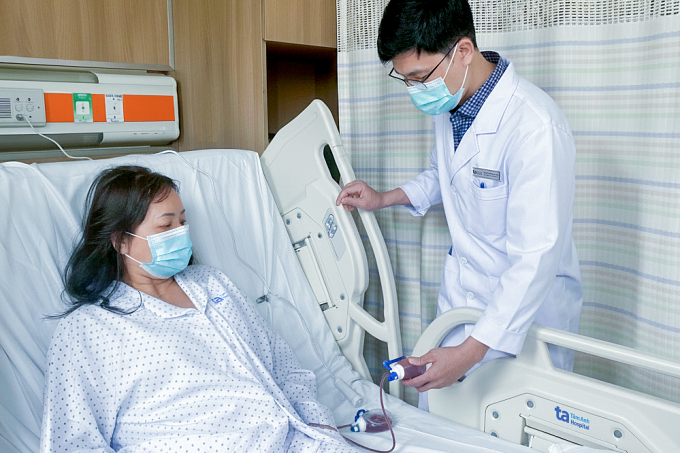 Bác sĩ Tấn thăm khám bệnh nhân Thắm sau mổ. Ảnh: Bệnh viện Đa khoa Tâm Anh