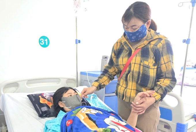 Cô gái được người chị chăm tại Bệnh viện Bình Dân. Ảnh: Nhung Trần