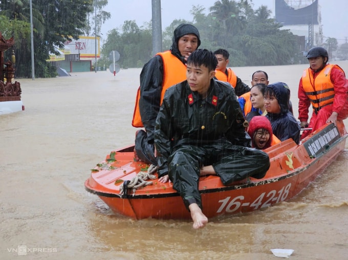 Lực lượng cứu hộ di dời người dân về nơi an toàn trong mưa lớn, ngày 20/11. Ảnh: Bùi Toàn