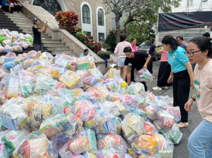 Các tình nguyện viên phân loại và khuân vác hàng cứu trợ các tỉnh Nam Trung Bộ sáng 22/11, tại  sân Ủy ban MTTQ phường Tân Định. Hàng trăm người dân mang quần áo, nhu yếu phẩm đến ủng hộ. Ảnh: Ngọc Ngân