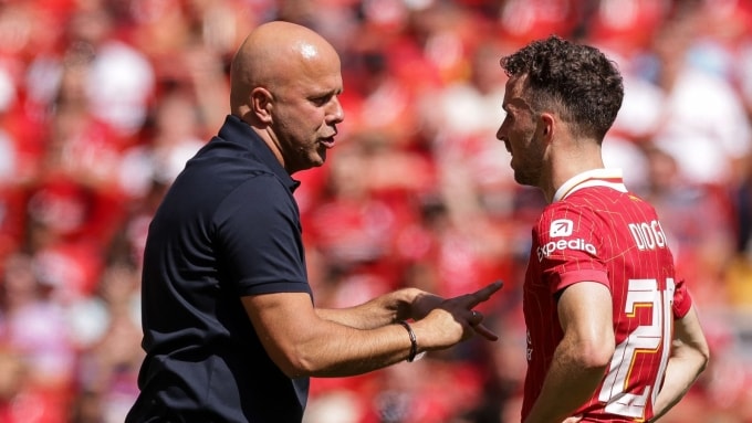 HLV Slot (trái) trao đổi chiến thuật với Jota tại Ngoại hạng Anh 2024-2025. Ảnh: PA