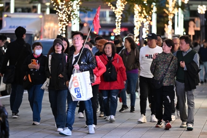 Đoàn du khách Trung Quốc tham quan khu phố mua sắm Ginza ở Tokyo ngày 17/11. Ảnh: AFP