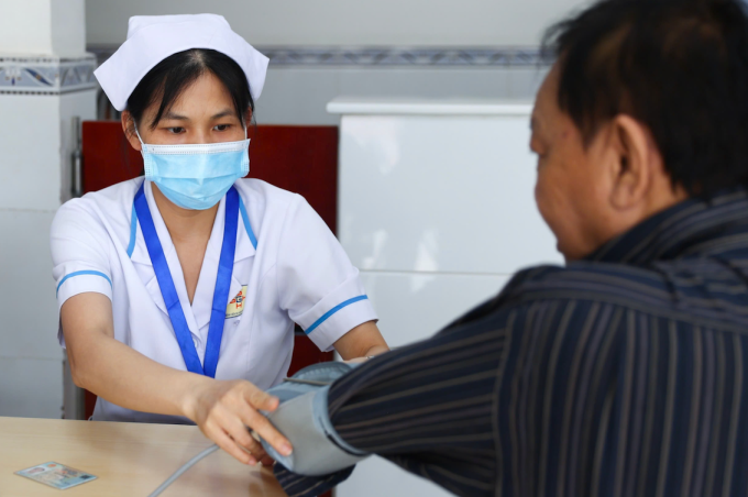 Nhân viên y tế đo huyết áp cho người dân. Ảnh: Quỳnh Trần