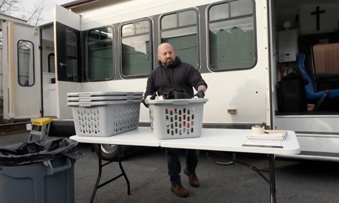 Wade Milyard trong một buổi gom quần áo bẩn từ người vô gia cư để giặt sấy miễn phí. Ảnh: CBS