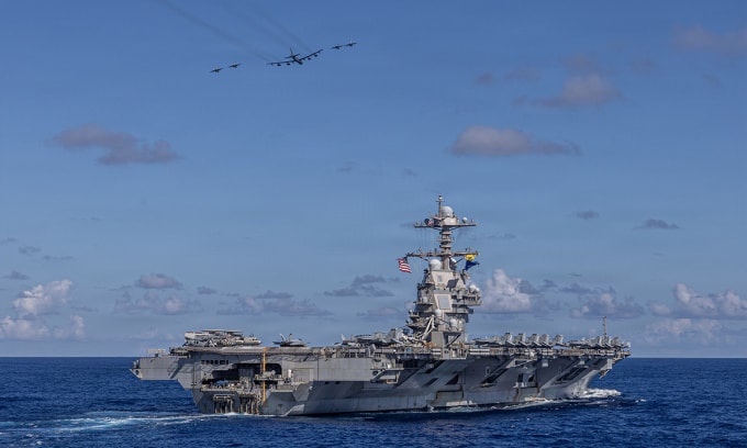 Tiêm kích F/A-18 và oanh tạc cơ B-52 bay qua đầu tàu sân bay USS Gerald R. Ford ở phía tây Đại Tây Dương ngày 13/11. Ảnh: US Navy