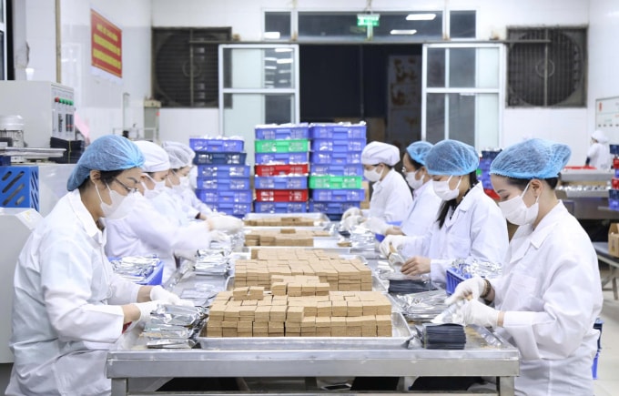 Công nhân Xí nghiệp 22 đóng gói lương khô cứu trợ miền Trung. Ảnh: Quỳnh Hương