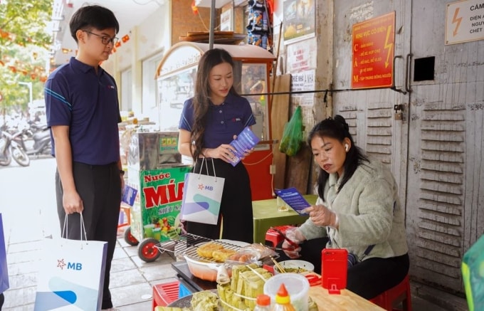 Nhân viên MB hướng dẫn tiểu thương chợ Hôm chuyển đổi số. Ảnh: MB