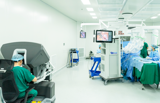 PGS Chuyên (trái) ngồi buồng điều khiển robot Da Vinci Xi thực hiện phẫu thuật ung thư tiết niệu. Ảnh: Bệnh viện Đa khoa Tâm Anh