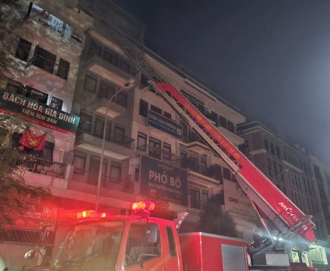 Cảnh sát phòng cháy dùng xe thang đưa 5 người thoát khỏi đám cháy. Ảnh: Thanh Thúy