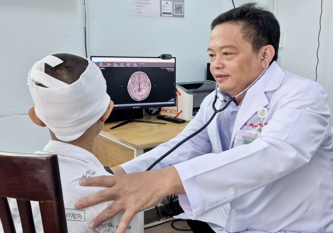 Bác sĩ Nguyễn Thành Đô thăm khám cho Long sau phẫu thuật. Ảnh: Lê Phương