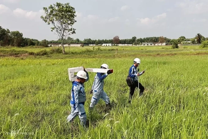Công nhân đi cắm cọc ranh giải phóng mặt bằng cao tốc TP HCM - Mộc Bài, tháng 3/2025. Ảnh: Quỳnh Trần