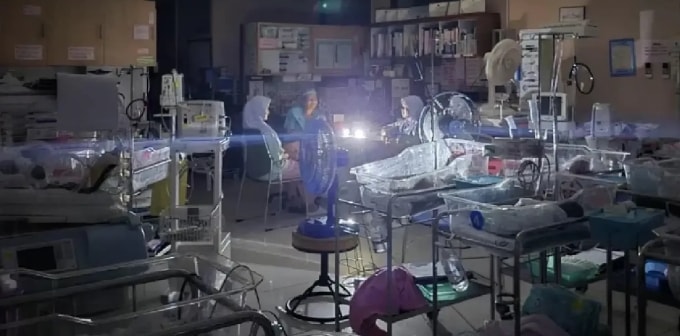 Nhân viên bệnh viện Hat Yai chăm sóc bệnh nhi sơ sinh ngày 24/11, hạn chế mở đèn để tiết kiệm điện cho các thiết bị quan trọng. Ảnh: Nation