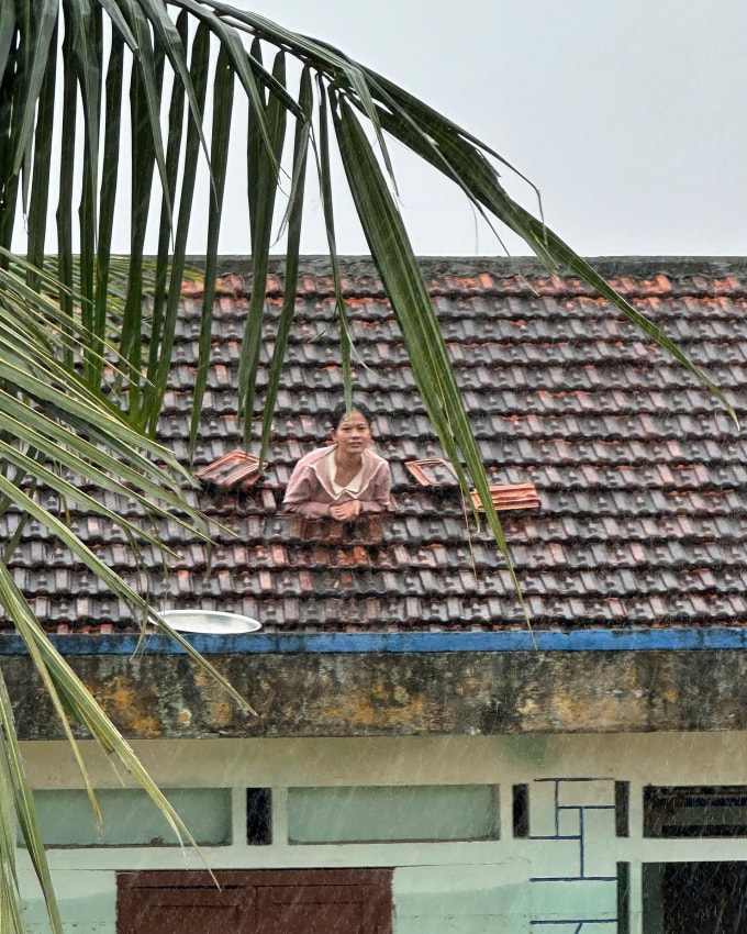 Người dân ở xã Hoà Xuân dỡ ngói chờ giải cứu vào sáng 20/11. Ảnh: Minh Bằng
