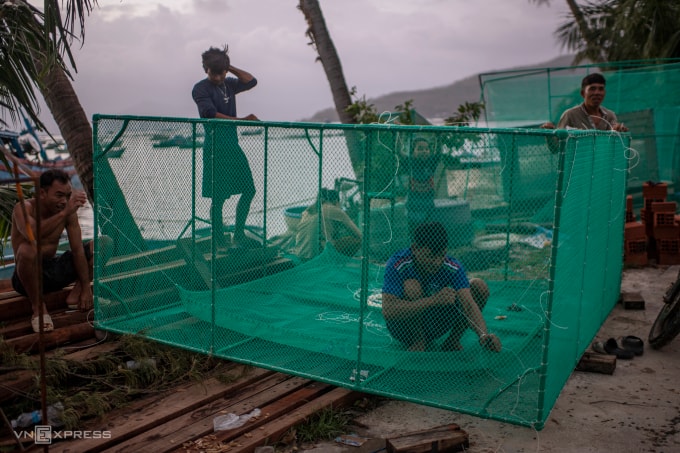 Anh Đoàn Văn Bi (áo xám) cùng bạn bè sửa lồng tôm hùm. Ảnh: Thanh Tùng