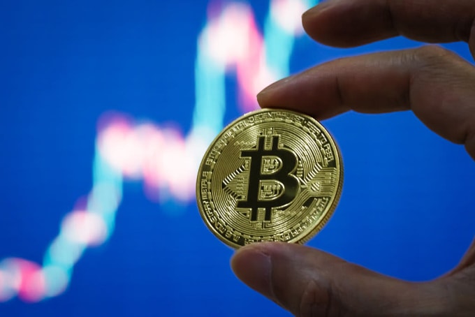 Một nhà đầu tư đang cầm biểu trưng Bitcoin. Ảnh: CNBC
