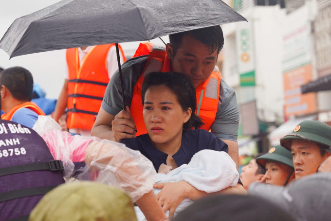 Người dân được lực lượng chức năng thoát khỏi dòng lũ xiết. Ảnh: VnExpress