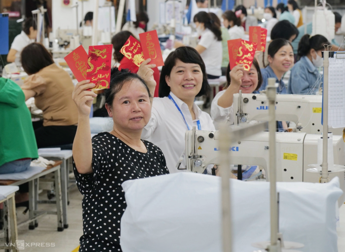 Công nhân May 10 (Hà Nội) nhận lì xì ngày đầu trở lại nhà máy sau kỳ nghỉ Tết Âm lịch. Ảnh: Ngọc Thành