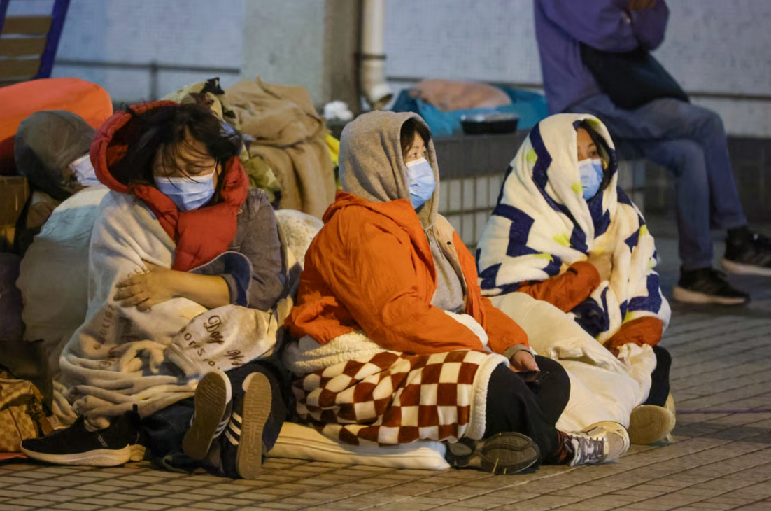 Người thân của những nạn nhân trong vụ cháy đang ngồi đợi tin tức. (Ảnh: Dickson Lee)