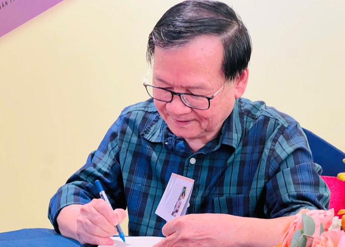 Nhà văn Nguyễn Nhật Ánh ký tặng sách mới tại họp báo. Ảnh: Hoàng Dung