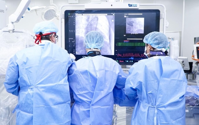 Các bác sĩ can thiệp cấy van động mạch chủ qua ống thông cho bệnh nhân. Ảnh: Trung Vũ