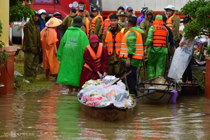 Cứu trợ người dân trong lũ ở xã Hòa Xuân. Ảnh: Thanh Tùng