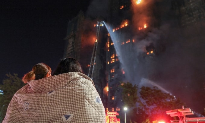 Cư dân đứng nhìn đám cháy tại các tòa chung cư thuộc khu Wang Fuk Court, Hong Kong, tối 26/11. Ảnh: Reuters