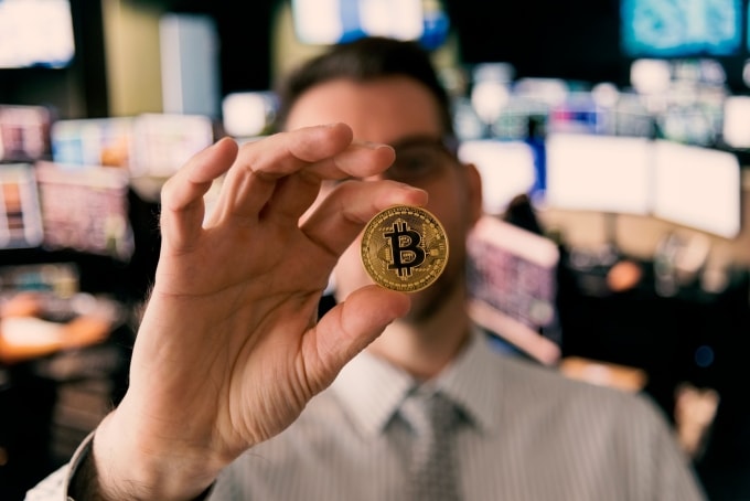 Một nhà đầu tư đang cầm biểu trưng của Bitcoin. Ảnh: CNBC
