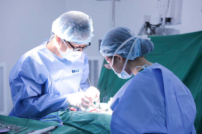 Bác sĩ Huân (trái) và ThS.BS Nguyễn Trần Nhật Khánh phẫu thuật cho bệnh nhân Hương. Ảnh: Bệnh viện Đa khoa Tâm Anh