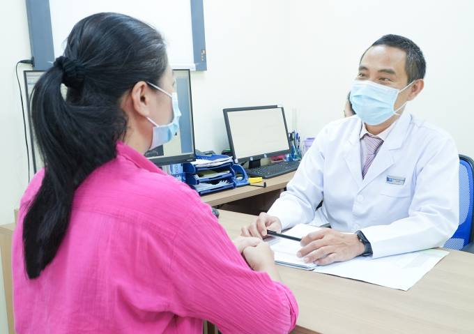 Bác sĩ Huân tư vấn phương pháp mổ điều trị ung thư da cho chị Hương. Ảnh: Bệnh viện Đa khoa Tâm Anh