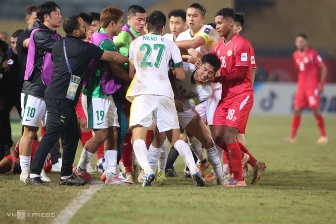 Cao Yongjing (áo trắng giữa) được kéo ra khỏi khu vực hỗn loạn sau khi phạm lỗi với Rogerio Alves. Ảnh: Hoàng Huynh.