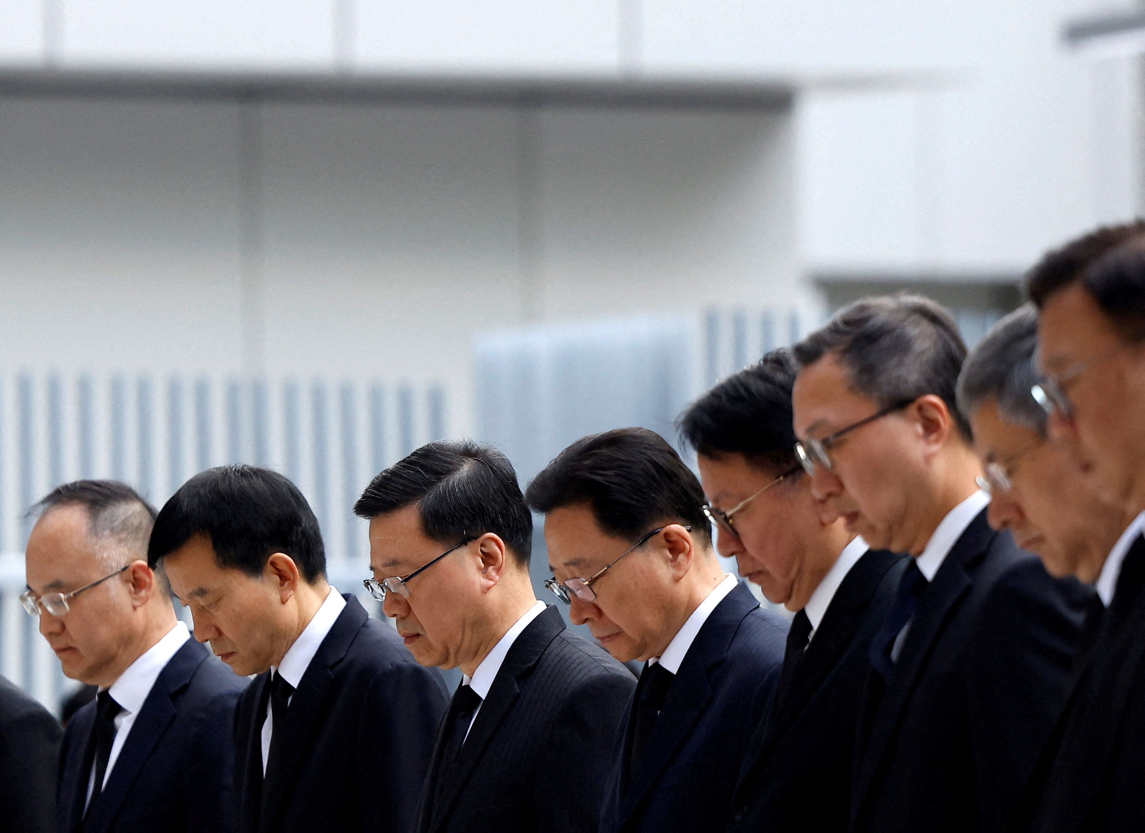 Trưởng Đặc khu Hong Kong Lý Gia Siêu cùng các quan chức cấp cao mặc niệm các nạn nhân vụ cháy khu chung cư Wang Fuk Court. (Ảnh: Reuters)