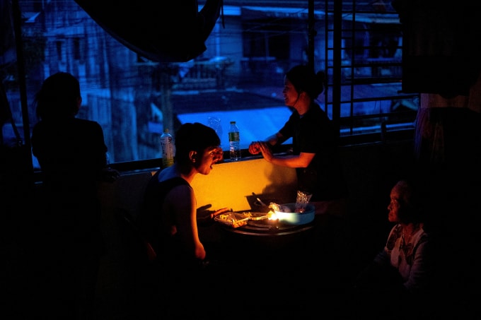 Gia đình Amphorn ăn tối dưới ánh nến khi điện mất trong mưa lũ ở thành phố Hat Yai, miền nam Thái Lan ngày 28/11. Ảnh: Reuters