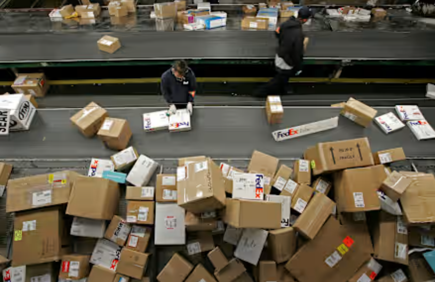 Một nhân viên FedEx đang phân loại các gói hàng tại Oakland, California, năm 2005. FedEx và UPS bắt đầu chứng kiến sự gia tăng các gói hàng khi mùa vận chuyển hàng ngày lễ bắt đầu với mức độ mua sắm trực tuyến cao.